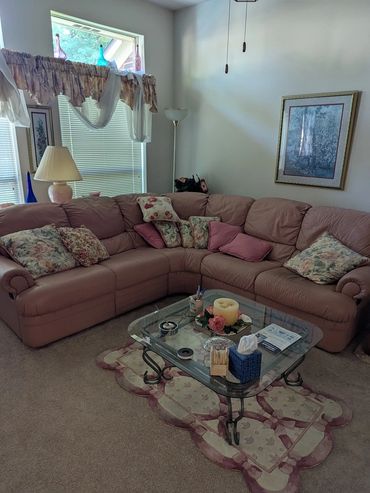 Cozy living room with a floral-themed sofa and glass coffee table.