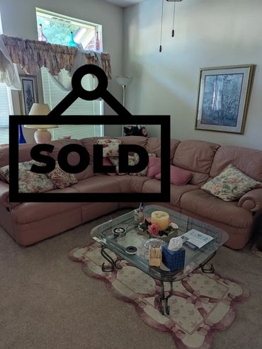 Cozy living room with a floral-themed sofa and glass coffee table.
