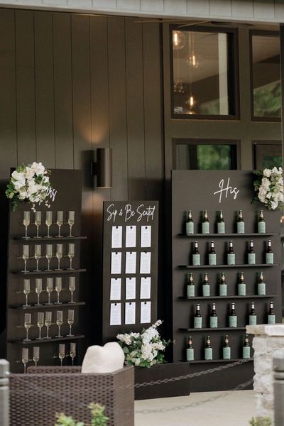 Elegant wedding drink stations labeled 'His' and 'Sip & Be Seated' with floral decorations.
