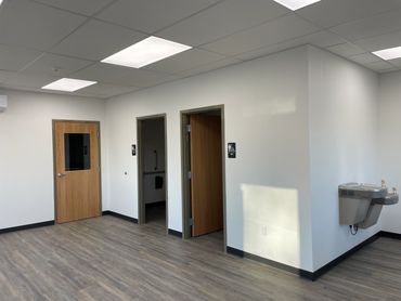 Room with two restroom doors and a water fountain.