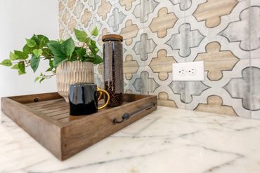 Decorative kitchen backsplash with marble countertop, wood cutting boards and plants