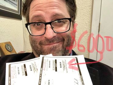 Guy holding cheques