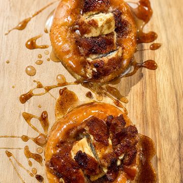 Two glazed doughnuts with cinnamon sugar and butter on top.