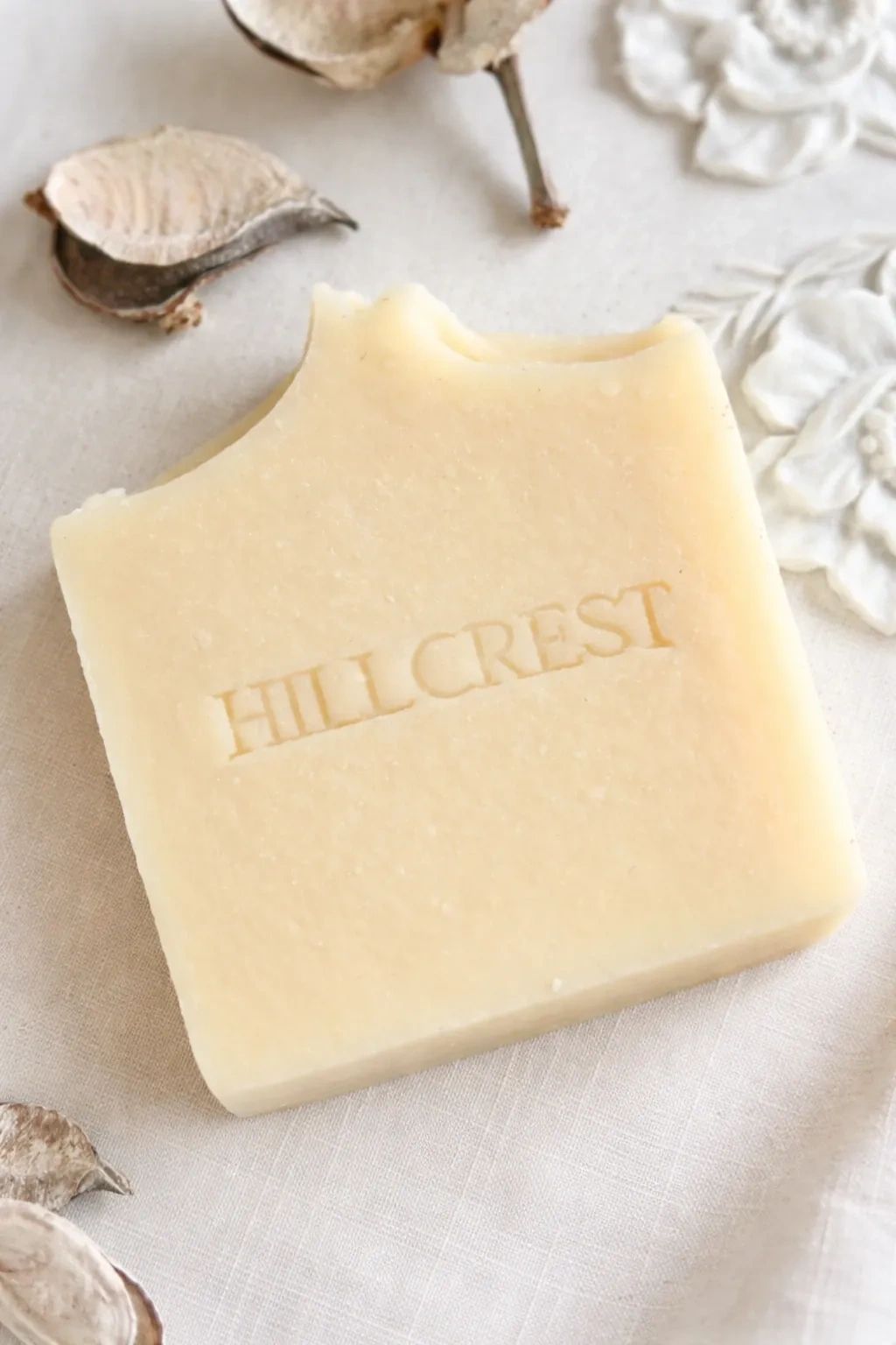 Square Hillcrest soap bar on a fabric with dried flowers.
