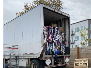 A truck loaded with compressed clothes bales is going to a toxic landfill in an industrial area.
