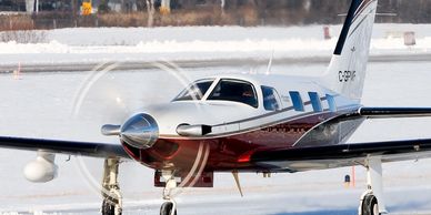 Small propeller airplane on snowy runway.