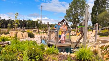 Family enjoying outdoor play area on a sunny day. Stonebridge Adventure Golf course near Birmingham West Midlands
