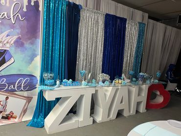 Decorated party table with large letters spelling ZIYAH and blue-themed decorations.