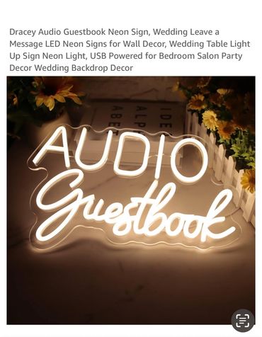 Illuminated neon sign reading 'AUDIO Guestbook' surrounded by decorative flowers.