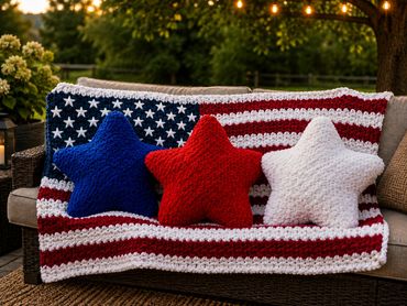 Crocheted American flag blanket with star-shaped pillows in red, white, and blue.