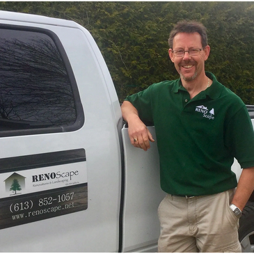 Man in green polo standing by a white RenoScape truck.