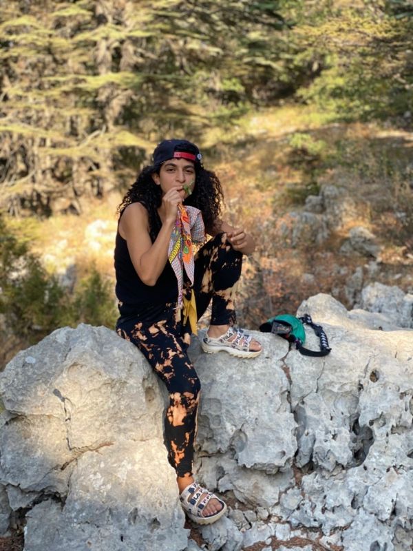 Person sitting on rocks outdoors enjoying nature.