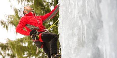Persona vista de perfil escalando una pared de hielo.