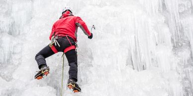 Persona escalando una pared de hielo