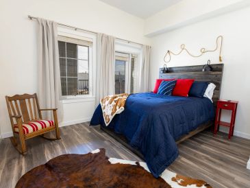 Cozy bedroom with blue bedding and rustic decor.