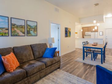 Cozy living room with brown sofa and dining area.