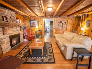 Cozy wooden living room with fireplace and leather furniture.