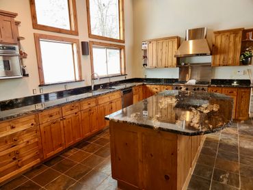 Rustic kitchen with wooden cabinets and granite countertops.