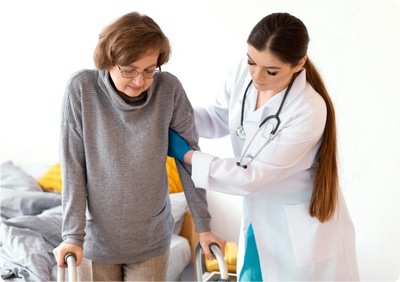 A doctor assists an elderly woman using a walker.