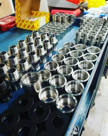 Organized metal threaded parts on a table.