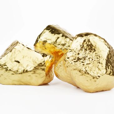 Three shiny gold nuggets on a white background.