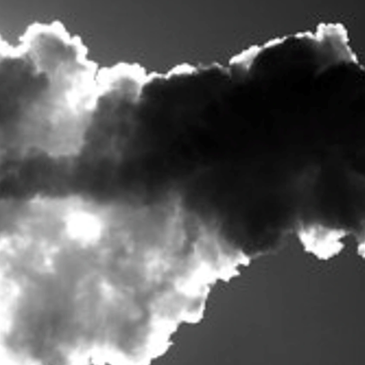 Billowing dark smoke against a bright sky.