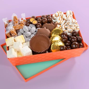 Assorted chocolates and sweets in an orange gift box.