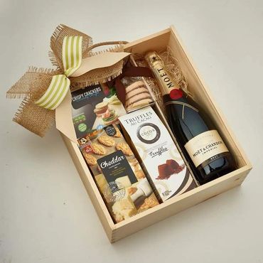 Gift box with champagne, crackers, cheese, and chocolates.