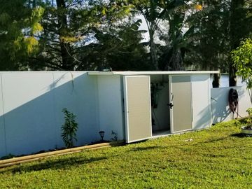 Outdoor storage shed attached to a fence built by Rhino Wall Systems.
