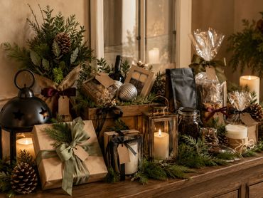 Cozy holiday gifts and candles on a wooden table.