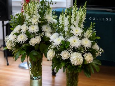 Two elegant white floral arrangements in glass vases.
