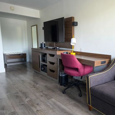 Modern living space with TV, desk, and comfortable seating.