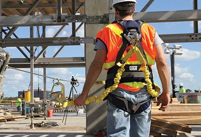 Man wearing a harness on a construction site.