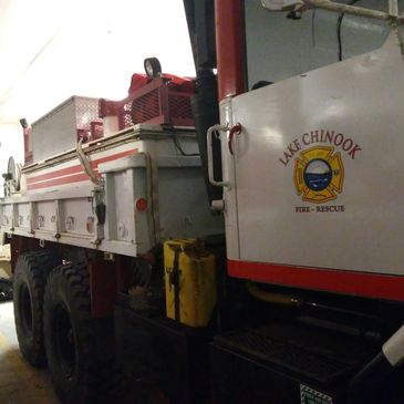 Side view of a fire department truck showing the fire department logo