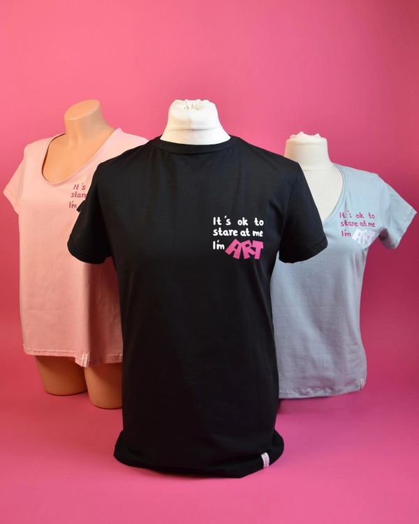 Vor pinkem Hintergrund 3 Büsten mit T-shirts in rosa, schwarz und hell blau mit einem ART Aufdruck.