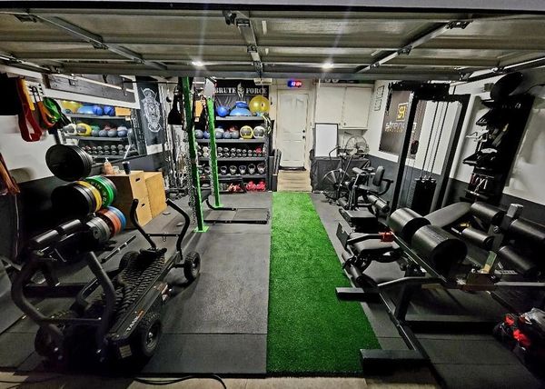 Well-equipped home gym with various fitness machines and weights.