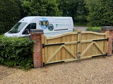 First Choice Garden Supplies van parked behind bespoke timber gates on a gravel driveway.