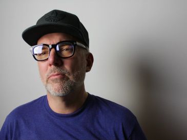 Man wearing glasses and a cap.