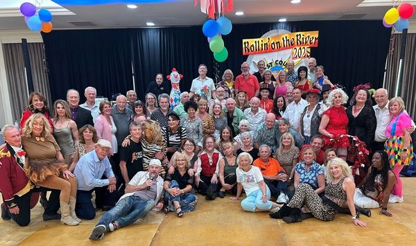 Large group photo at Rollin' on the River 2023 event with festive decorations.