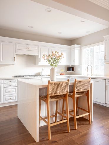 White coastal kitchen with natural bar stools.