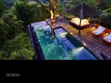 Luxury outdoor deck with pool and lounge chairs surrounded by lush greenery.