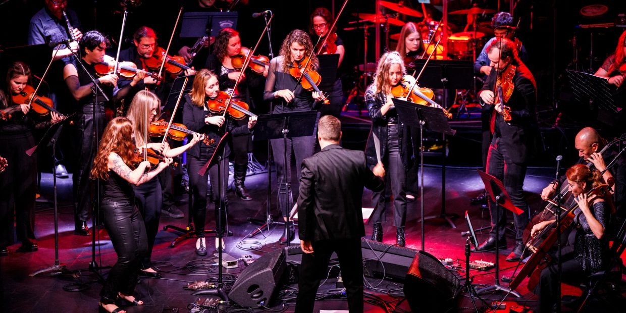 Orchestra performing on stage with conductor.