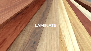 Various laminate wood flooring samples displayed with the word 'LAMINATE' in the center.