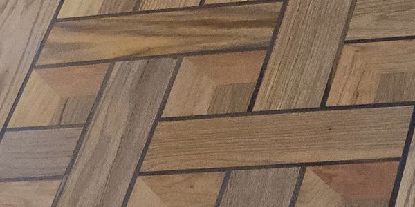 Intricately patterned wooden parquet floor with geometric designs.