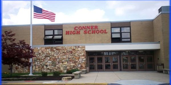 Front view of Conner High School with American flag.
