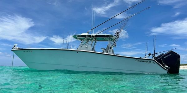 Fishing boat anchored in clear turquoise waters under a blue sky.