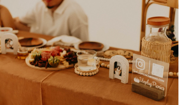 Cozy picnic setup with snacks, a glass of water, and Unplug Picnics info card.