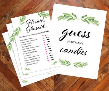 Decorative baby shower game cards with leafy designs on wooden floor.