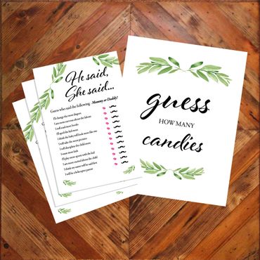 Two baby shower game cards with leafy designs on a wooden surface.