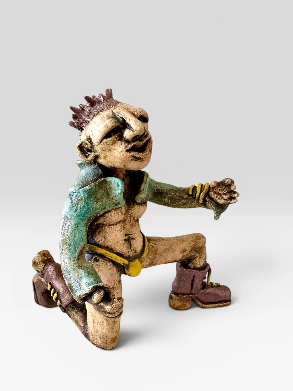 Abstract clay figurine with spiked hair and boots in a dynamic pose.